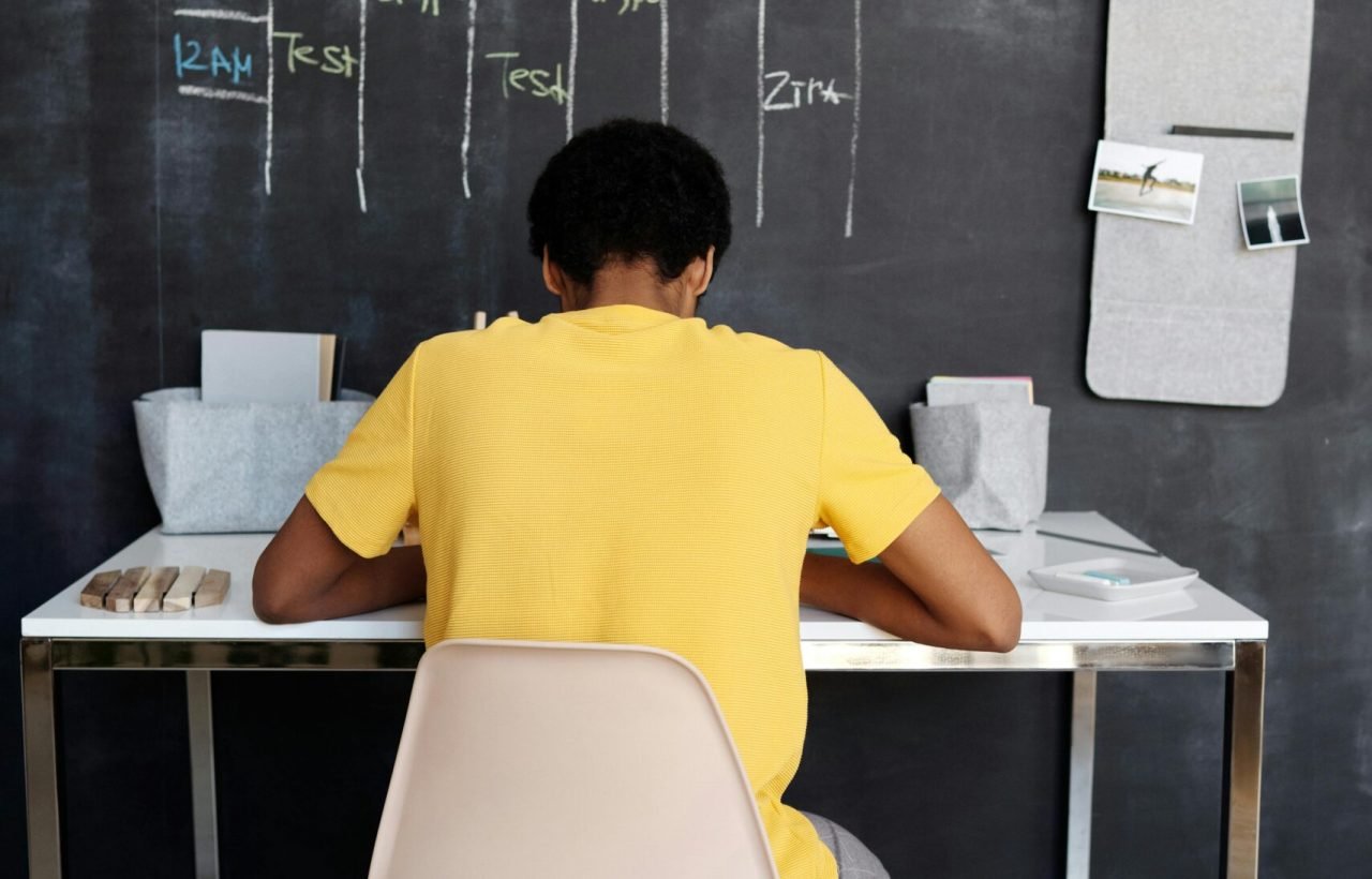 Boy in Yellow Crew Neck T-shirt Sitting on Chair